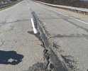 ФАД "Колыма" 1952-1953 км. Сползание дорожного покрытия с насыпи с разрывами. Трещины, разрушение дорожного покрытия.