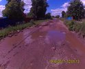 Убитая дорога на ул Первомайская, состоит из грязи и воды..