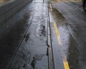 Из-за оставшихся после демонтирования трамвайной линии выбоин на дороге и отсутствия нормальной системы слива во время дождя улица превращается в "реку"