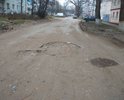 Глубокие ямы на дороге за домом номер 24 в переулке Комсомольском.