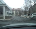 разбитая проезжая часть с многочисленными ямами на ул. Ольшанского вдоль магазина "Мебель Черноземья"