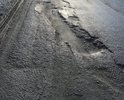 На опасном участке дороги (спуск с поворотом, сужение под путепроводом) дорожное полотно разбито имеются глубокие ямы создающие опасность для дорожного движения.