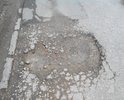 Яме уже скоро год!глубина ямы от 15см до 23см. Приходится выезжать на встречку чтоб проехать между ямами,очень опасно т.к. за углом поворот!