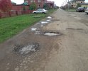 На данном участке дороги наблюдаются отдельные повреждения дорожного полотна (выбоины, трещины, деформации и разрушения), а также систематическое скопление дождевых вод (существующий ливнесток в виде металлической трубы с отверстиями не эффективен).