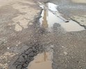 На данном участке дороги наблюдаются отдельные повреждения дорожного полотна (выбоины, трещины, деформации и разрушения), а также систематическое скопление дождевых вод (существующий ливнесток в виде металлической трубы с отверстиями не эффективен).