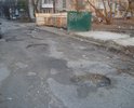 Колоссальное количество ям, полусгнивший дорожный знак, разбитый тротуар.