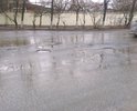 Покрытие улицы разрушено полностью, на улице много луж под которыми большие ямы.