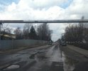 Дорога с большим количеством ям. Автомобили на некоторых участках объезжают по газонам. Засыпка крупным щебнем некотрых ям не помогла