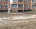 Дорога с большим количеством ям. Автомобили на некоторых участках объезжают по газонам. Засыпка крупным щебнем некотрых ям не помогла