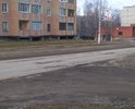 Дорога с большим количеством ям. Автомобили на некоторых участках объезжают по газонам. Засыпка крупным щебнем некотрых ям не помогла