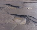 Разбитая дорога. Многочисленные ямы различных размеров, в том числе крупные.