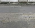 На дородном полотне имеется множество дефектов требующих ремонта, включая чрезмерно выпирающий над уровнем дороги канализационный люк.
