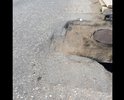 Неровная дорога с ямами и латками, если обратить внимание на люк сразу бросается в глаза, что люки это конек дорожников города Каспийска , а в данном случае они превзошли сами себя