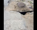 Неровная дорога с ямами и латками, если обратить внимание на люк сразу бросается в глаза, что люки это конек дорожников города Каспийска , а в данном случае они превзошли сами себя