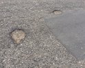 Неровная дорога с ямами и латками, если обратить внимание на люк сразу бросается в глаза, что люки это конек дорожников города Каспийска , а в данном случае они превзошли сами себя
