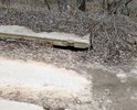 Покрытие дорожными плитами. Часть плит подмыло ручьем и одна плита сильно просела. По этой дороге люди возят детей в школу и дет.сад, ездят на работу, т.к. автобусного сообщения нет. Если так и оставить, плита под чьим нибудь автомобилем провалится совсем. Аварийно опасный участок.