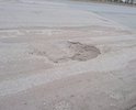 Участок от перекрёстка Космонавтов-Дзержинского до моста, с обеих сторон крайние полосы (Ямы, и кирпич). Кирпич - не является асфальтом. Наличие ям с глубиной в ширину кирпича - не является нормой.