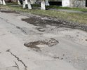 Активное разрушение асфальта (трещины, ямы, просадка колодцев) на всей улице. На перекрестке с ул. Победы, посреди улицы, прямо из-под асфальта торчат деревянные палка (сваи?) непонятного происхождения и назначения