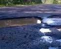 ямы в асфальте, местами засыпанные гравием