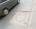 Образовалась глубокая выбоина на дороге (возле дорожного люка) напротив дома, расположенного по адресу ул. Комсомольский 39/4