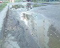 Дорога у дома, находящегося на улице Лесная 5 (Комсомольский поселок), в ужасном состоянии. По всей дороге ямы, лужа практически не высыхает, трудно проезжать на машине, в дождь не выйти из подъезда.