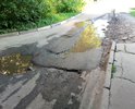 Огромная яма при въезде во двор. Въезд машинам затруднён. В яме всегда скапливается вода и грязь. Яме уже более 2-х лет. С каждым годом её размывает все глубже и шире. Так же пострадал тротуар вдоль этой дороги.