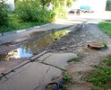 Огромная яма при въезде во двор. Въезд машинам затруднён. В яме всегда скапливается вода и грязь. Яме уже более 2-х лет. С каждым годом её размывает все глубже и шире. Так же пострадал тротуар вдоль этой дороги.