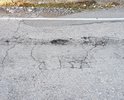 На участке подъема от Южнобережного шоссе к Старому Севастопольскому шоссе встречаются трещины и выбоины в асфальте; в некоторых местах дорожное полотно деформируется; люк не закрыт - крышка отсутствует; на дороге разлит и засох бетон.