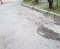 На участке Таврического проезда глубокие трещины, ямы и выбоины в асфальте; асфальт крошится и размывается.