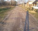 Дорога превратилась в грунтовую. Жители собственных домов за свой счет засыпают ямы строительным мусором или землей.