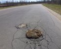 Из асфальтового покрытия на 5 см выступает пень от дервянного столба.