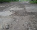 Бетонное покрытие дороги сильно разрушено. Большегрузами выдавлены обломки бетонных плит.