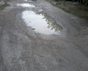 дорога имеет огромные ямы, необходимо выравнять дорогу в гравийном исполнении