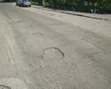 Латанное-перелатанное дырявое дорожное покрытие требует ремонта.