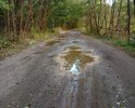 Ямы и асфальт, покрытый толстым слоем песка и грязи