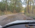 Ямы и асфальт, покрытый толстым слоем песка и грязи