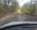 Ямы и асфальт, покрытый толстым слоем песка и грязи