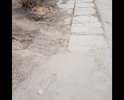 Убитая пешеходная дорожка из плит времен СССР, которые в одном из двух состояний - или лопнули или их перекосило.