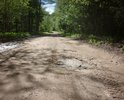 Дорога межмуниципального значения, 28 ОП МЗ 28Н-1448, 3 класс, Трофимково - Козловцы – Дрыгомо, в т.ч.  («Трофимково-Козловцы» - 3,3 км – асфальтовое покрытие, «Козловцы - Дрыгома» - 8 км – гравийный участок дороги).

Участок дороги: "дер. Козловцы - дер. Выставка"

======================================
Не забывайте и не жадничайте поддерживать наши селижаровские дороги:

в частности,

https://dorogi-onf.ru/problem/55397/.

Больше голосов за районные проблемные участки - больше вероятность ремонта районных дорог!

============================
Состояние: 
1. Лопнули две мостовые трубы с образованием проломов. 
2. Гравийная дорога в своём продолжении имеет колеи, выбоины, волны, пластические дефекты (сдвиги, наплывы, гребенка).
3. Участок дороги «Козловцы-Выставка» (частично) – ненормативная ширина дороги, разрастание древесной растительности по обочинам, зарастание дороги, привели к сужению пространства и оставлению возможности лишь одностороннего проезда транспорта.
=========================

Описание: После выезда из деревни Козловцы в сторону Дрыгомы – асфальт заканчивается и начинается грунтовая дорога. Гористая и интересная. Одно удовольствие на велике катиться от телецентра с горушки… Но ездить может только тот, кто знает дороги. Три холма и вот у поворота на дер. Горицы одна из самых важных и древних достопримечательностей в окрестных местах – необычайно глубокая, наглая и самодовольная лужа, непересыхающая даже в засуху к зависти протекающего рядом с дорогой ручья. Скорее всего, она прописалась там после разрыва снаряда в какую-то давнюю войну – кто ж теперь знает, да и она сама, наверное, не помнит… Затем, по ходу движения, после поворота на Горицы и Пронино, начала бывшей деревни Выставки идут колеи, в солнечную погоду мирно дремлющие в тени деревьев, но в дождь злобно прячущие свои истинные зловещие планы и мечты под лужами, обнажая свою вязкую, гадкую суть и зловредные планы лишь тогда, когда представится возможность заключить в свои крепкие и нежные объятия  очередное самоуверенное и неопытное колесо.