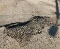 Большие ямы, достаточной глубины для повреждения автомобиля, а так же насыпи песко-соляной смеси на протяжении всего участка дороги.