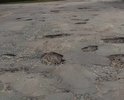 Все дороги посёлка Молодогвардейцев Анжеро-Судженска в плачевном состоянии. Машины едут со скоростью 10 км в ч. Быстрее не могут, так как огромные ямы.