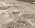 Дорога идущая от города (района) Вятские Поляны до конца деревни Нижние Шуни Вятскополянского района Кировской области разрушена и имеются отслоения верхнего слоя асфальта, проседания либо выпучивания грунта из под дорожного покрытия, большие трещины в асфальте. Вышеизложенные дефекты дорожного полотна не соответствуют предельно допустимым нормативным размерам, в соответствии с требованиями ГОСТ Р 50597-2017 «Автомобильные дороги и улицы. Требования к эксплуатационному состоянию, допустимому по условиям обеспечения безопасности дорожного движения». 
Жителями деревень Средние Шуни, Сосмак, Нижние Шуни неоднократно писались обращения, жалобы в ГИБДД, на имя главы Вятскополянского района Кировской области, однако до сих пор никаких мер по асфальтированию дорог на вышеуказанном участке дороги не принято. Из полученных ответов следует только одно, что нет бюджетных средств на ремонт и.т.п., а проблема так и не решается.
Я и жители Среденешунского сельского поселения Вятскополянского района Кировской области не просят ни в коем случае подводить дорогу к каждому дому, просто нам нужна одна, центральная дорога, соединяющая нашу деревню с цивилизацией (от города Вятские Поляны до конца деревни Нижние Шуни). При необходимости до деревни Нижние Шуни, Средние Шуни, Сосмак, не может вовремя доехать машина скорой помощи, служба спасения, пожарная машина и полиция, что ставит под угрозу мое здоровье и безопасность, а также здоровье и безопасность членов моей семьи и жителей. В итоге опасные ситуации на дорогах, возникающие в данных населенных пунктах Сосмак только усугубляются и могут закончится человеческими жертвами. Все это вышеуказанное нарушает наши права и свободы (граждан): 
- свободу передвижения (ст. 27, п. 1 Конституции Российской Федерации);
- право на передвижение по качественным дорогам, на ремонт и обустройство которых мы жители ежегодно производим налоговые отчисления (согласно ст. 357, глава 28, раздел IX, часть II Налогового кодекса Российской Федерации). Прошу Вас оказать помощь по асфальтированию дороги в деревне Нижние Шуни, Сосмак, Средние Шуни.