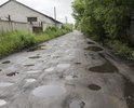 Состояние видно по фотографиям. Больше 5км/ч не разгонишься, в некоторых местах уже цепляешь днищем автомобиля, ходовая часть автомобилей разбивается, кузов весь кренит, в общем  ездить невыносимо. Каждый год одно и тоже, но в этом еще хуже, так как на протяжении двух месяцев ни какие меры по приведению в порядок не принимались.
Хотелось бы знать:
1) когда планируется асфальтирование данного участка,
2) в случае отсутствия указанной дороги в планах строительства, когда будут приняты меры по приведению к соответствию нормативным требованиям.