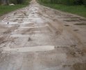 От въезда  на дорогу ведущую к деревне и далее по ней  неровности, ямы. Дорога разбитая. Год назад въезд засыпали песком, но ямы через него уже снова проявились. Грейдером ситуацию уже не исправить.