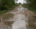 От въезда  на дорогу ведущую к деревне и далее по ней  неровности, ямы. Дорога разбитая. Год назад въезд засыпали песком, но ямы через него уже снова проявились. Грейдером ситуацию уже не исправить.