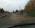Старый разбитый асфальт, вместо люков прямо по середине дороги лежат автомобильные покрышки.