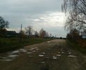 Так выглядит  дорога с а/б покрытием, после того как песок и гравий из смеси, которой её засыпали лет 12 назад чтобы прикрыть выбоины, снесло с помощью природы и человека на обочины. Последние два года процесс разрушения полотна ускорился и теперь это  езда с препятствиями.  В сухую погоду деревня задыхается от пыли, а зимой в сильные морозы дорога превращается в каток, так как посыпать песчано-солевой смесью нельзя, для дороги лучше чтобы она была в "ледовом панцире" объясняют дорожные службы.
