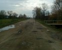 Так выглядит  дорога с а/б покрытием, после того как песок и гравий из смеси, которой её засыпали лет 12 назад чтобы прикрыть выбоины, снесло с помощью природы и человека на обочины. Последние два года процесс разрушения полотна ускорился и теперь это  езда с препятствиями.  В сухую погоду деревня задыхается от пыли, а зимой в сильные морозы дорога превращается в каток, так как посыпать песчано-солевой смесью нельзя, для дороги лучше чтобы она была в "ледовом панцире" объясняют дорожные службы.