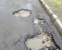 Убитая дорога по дороге в школу 296 . Глубокие ямы долгое время не ремонтировались.В дождливую погоду прохожие обливаются проезжающими водителями.
