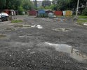 Дорога у площадки ТКО и территория за самой площадкой. Пару десятков лет назад большое пространство перед площадкой ТКО (на первом фото) было асфальтировано. Асфальт со временем пришел в негодность, ремонтные работы на этом участке никогда не проводились, хотя это одна из дорог к 1 школе, к техникуму, проезжая часть и по совместительству подход к площадке ТКО. Недавно участок перед ТКО и за площадкой ТКО посыпали асфальтобетонным ломом, как временное решение. Просим организовать укладку асфальта на этой проезжей части, перед ТКО и убрать остатки асфальтобетоного лома за ТКО, асфальтировав пространство вокруг мусорной контейнерной площадки.
